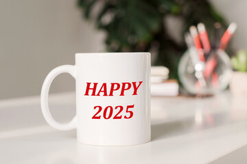 A white coffee mug inscribed with Happy 2025 is placed on a desk in a contemporary office, perfect for welcoming the new year with positivity