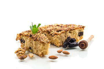 Ruddy sponge cake with prunes and nuts for tea, isolated on white background