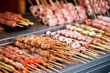 A close-up of frozen skewer ingredients at a night market stall. These pre-assembled skewers are stored in refrigerated displays, ensuring freshness before grilling.