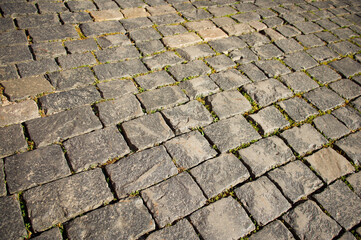 The texture of the paving stones on the square. Old grey stones.