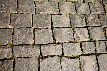 The texture of the paving stones on the square. Old grey stones.
