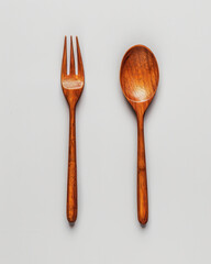 Rustic Elegance: A wooden spoon and fork, crafted with care, lie side by side, showcasing a simple yet refined aesthetic that evokes a sense of warmth and natural beauty.