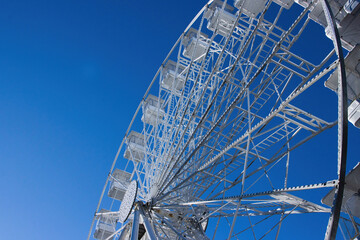 white big ferris wheel fair ride against a blue sky
