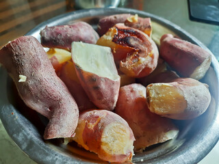 Close up of Baked yellow sweet potato, Japanese sweet potato in wooden plate on old wooden table.