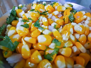 Sweet Corn Chat or Steamed yellow sweet corn, Chat Masala on a plate closeup in the table.