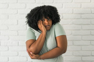 Portrait of a scared african american woman over brick background