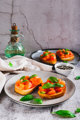 Appetizing bruschetta with tomatoes, garlic and basil on a plate on the table vertical view
