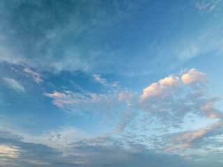 Bright blue sky with soft clouds during early morning hours over a tranquil landscape