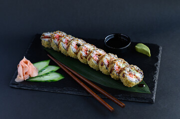 A set of sushi rolls on a wooden board and banana leaf, served with soy sauce, wasabi, ginger, and chopsticks. Perfect for an Asian restaurant menu.