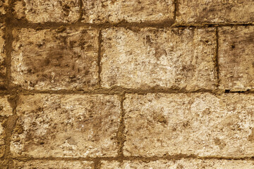 The rustic surface of a stone wall lining Malta's historic passageways.