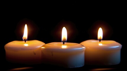 Three lit candles against a dark background creating a warm ambiance.