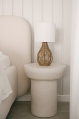 Beautiful light beige interior with soft white bed decorated with pillows in japandi and wawabi sabi style, cozy home concept