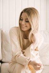 Beautiful blonde woman posing in a beautiful modern stylish beige interior