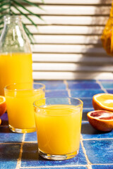 Fresh orange juice on table with slices fruits.