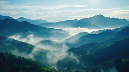 Naklejka premium Majestic mountain landscape with mist and serene atmosphere under a clear blue sky.