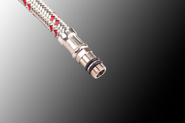 Hose in metal braiding. Designed to connect water to the washbasin. mixer. Close-up.