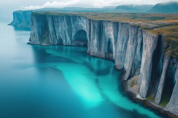 Majestic cliffs rise above tranquil turquoise waters in remote Arctic landscape