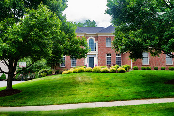 Obraz premium large country house in the English style with a large mowed lawn in front of the entrance.