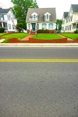 Small cute house by the road. View of the porch with lawn and walkway. Space for text.