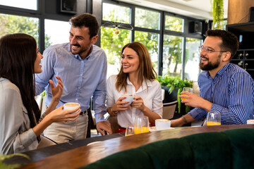 Group of friends met at the restaurant. They hang out, drink coffee and laugh.