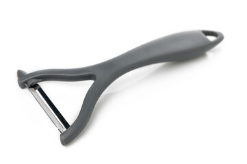 Sleek vegetable peeler resting on a white surface after preparing fresh ingredients in the kitchen