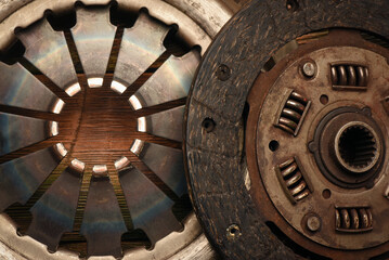Automobile clutch disc and pressure plate on a workbench background top view.