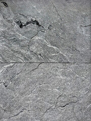 Close up of natural grey stone granite with random black veins and 3D texture. Giant grey and black granite slab, natural stone pattern suitable for wall clads. Seamless background texture