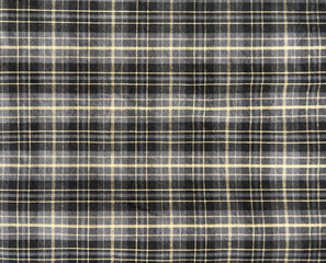 Close up of table cloth runner with black, grey, beige, and white lines tartan pattern. Tartan style is very common in scarf, shirts, and fashion industry. Seamless background texture.