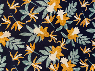 Fabric in random leaves and flowers pattern, brown, beige, and light blue leaves with dark blue...