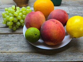 peaches on a plate surrounded by other fruits. high-quality photo