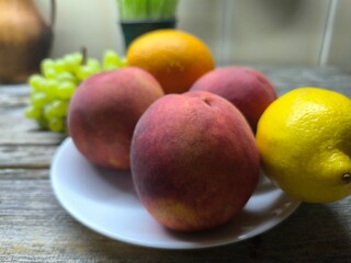 peaches on a plate surrounded by other fruits. high-quality photo