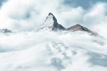 Digital Composition of snow-covered hill with snow tracks in front of the majestic matterhorn mountain