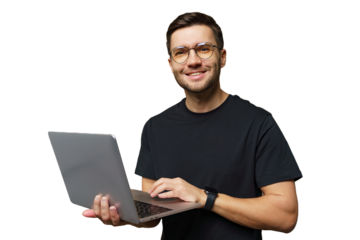 Young man using a laptop while smiling, showcasing creativity and focus in modern workspace