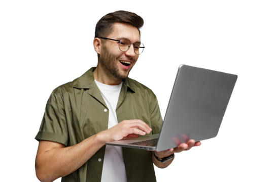 Excited man using laptop with joy in a modern workspace setting while wearing casual attire