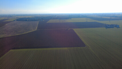 Panorami dal drone della Pianura Padana con campi di grano, campi seminati e terreni di terra rossa...