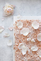 Napoleon Cake decorated with flowers on a white stone background, top view. A delicious cake...
