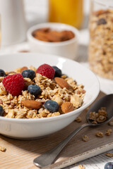 breakfast with homemade granola with nuts and berries, vertical closeup
