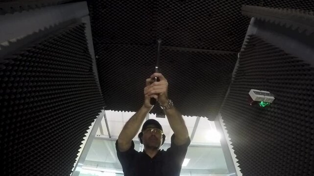 man firing a gun S&W 357 magnum at a shooting range, front view. Slow motion video