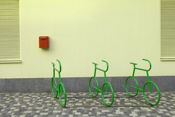 Bicycle parking place against a yellow wall. Original bicycle parking design