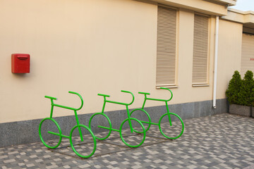Bicycle parking place against a yellow wall. Original bicycle parking design
