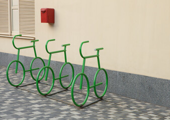 Bicycle parking place against a yellow wall. Original bicycle parking design