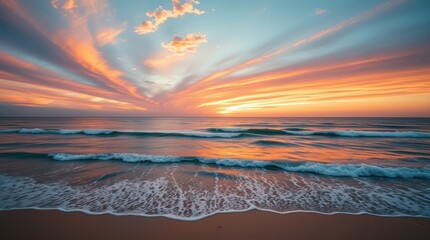 Sunset paints the sky and ocean with vibrant orange hues, casting a golden glow on the sandy beach