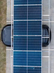 Effective photovoltaic solar panel installation over a parked black vehicle in an urban area during...