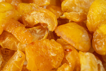 A close-up view of vibrant golden-yellow freeze-dried quince pieces against a white background. The texture and detail of the dried fruit are highlighted.