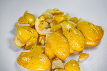 A close-up view of vibrant golden-yellow freeze-dried quince pieces against a white background. The texture and detail of the dried fruit are highlighted.