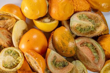 A vibrant collection of freeze-dried tomatoes in a mix of whole and sliced pieces. The rich textures and earthy tones highlight the preservation process.