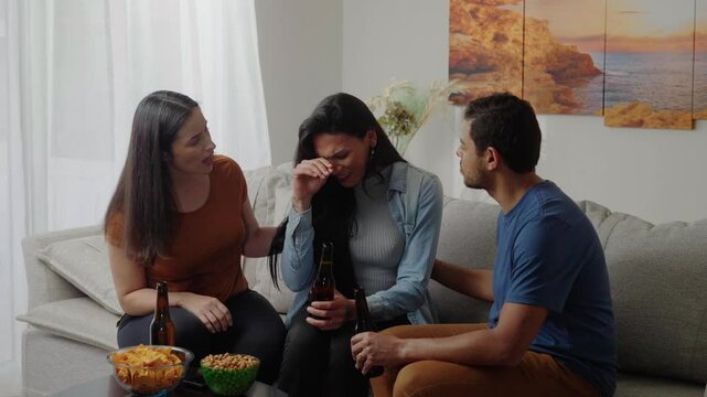 Support group of mates comforting depressive transgender crying friend, touching shoulder of unhappy frustrated transwoman with sympathy, talking, sitting in circle, discussing problems
