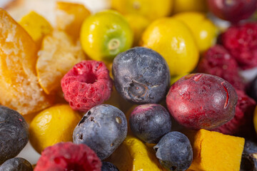 A vibrant mix of freeze-dried blueberries, physalis, cranberries, raspberries, apples, and pumpkin cubes. This colorful assortment showcases a variety of textures and natural colors, perfect for snack