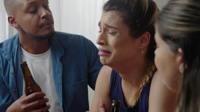 Support group of mates comforting depressive transgender crying friend, touching shoulder of unhappy frustrated transwoman with sympathy, talking, sitting in circle, discussing problems
