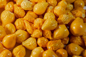 A detailed close-up of freeze-dried Argentine chili peppers, showcasing their vibrant yellow color, glossy texture, and seeds. Perfect for culinary or spice applications.